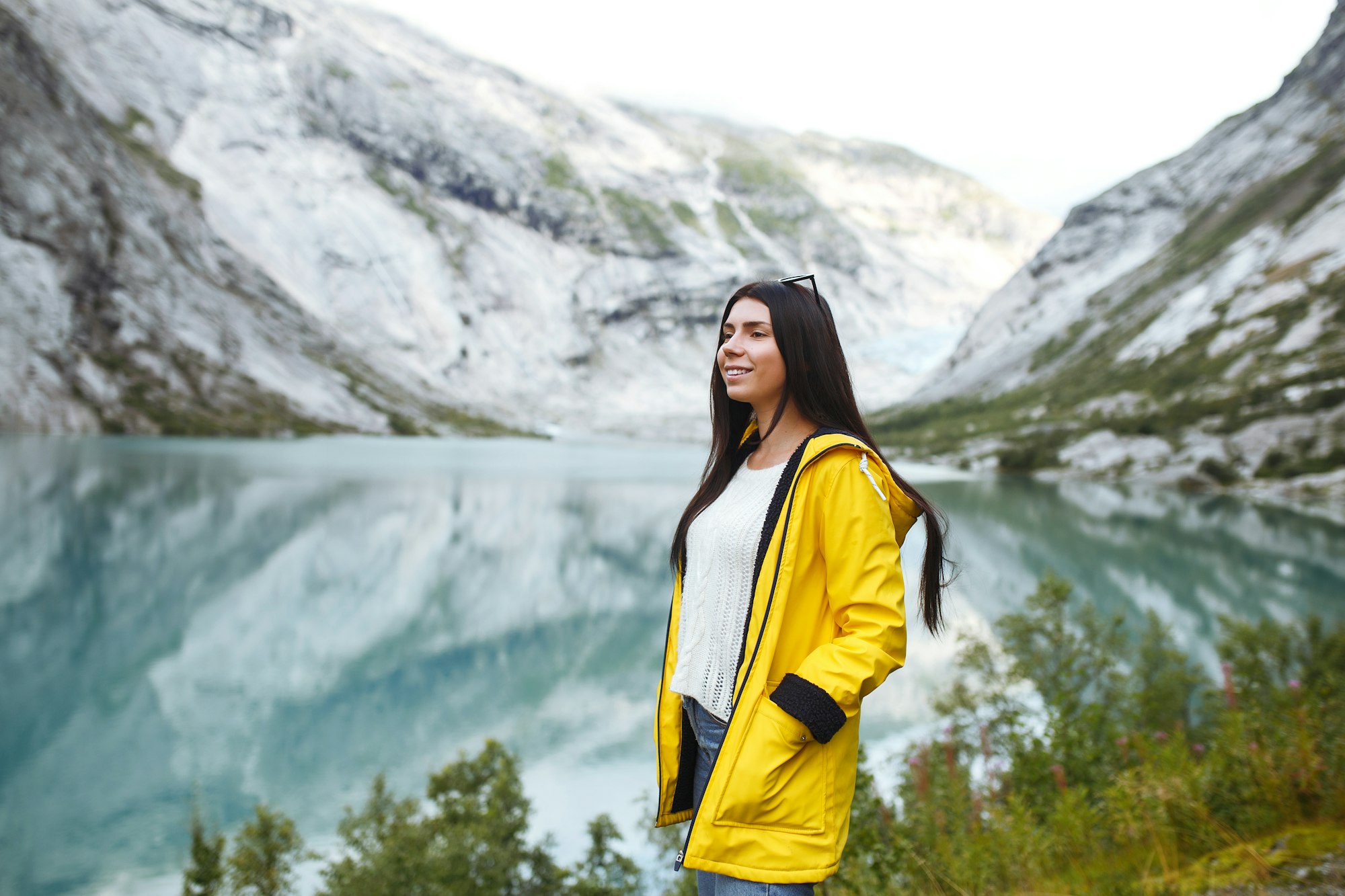 girl tourist in yellow jacket posing on the lake in norway active woman relaxing in the norway .jpg
