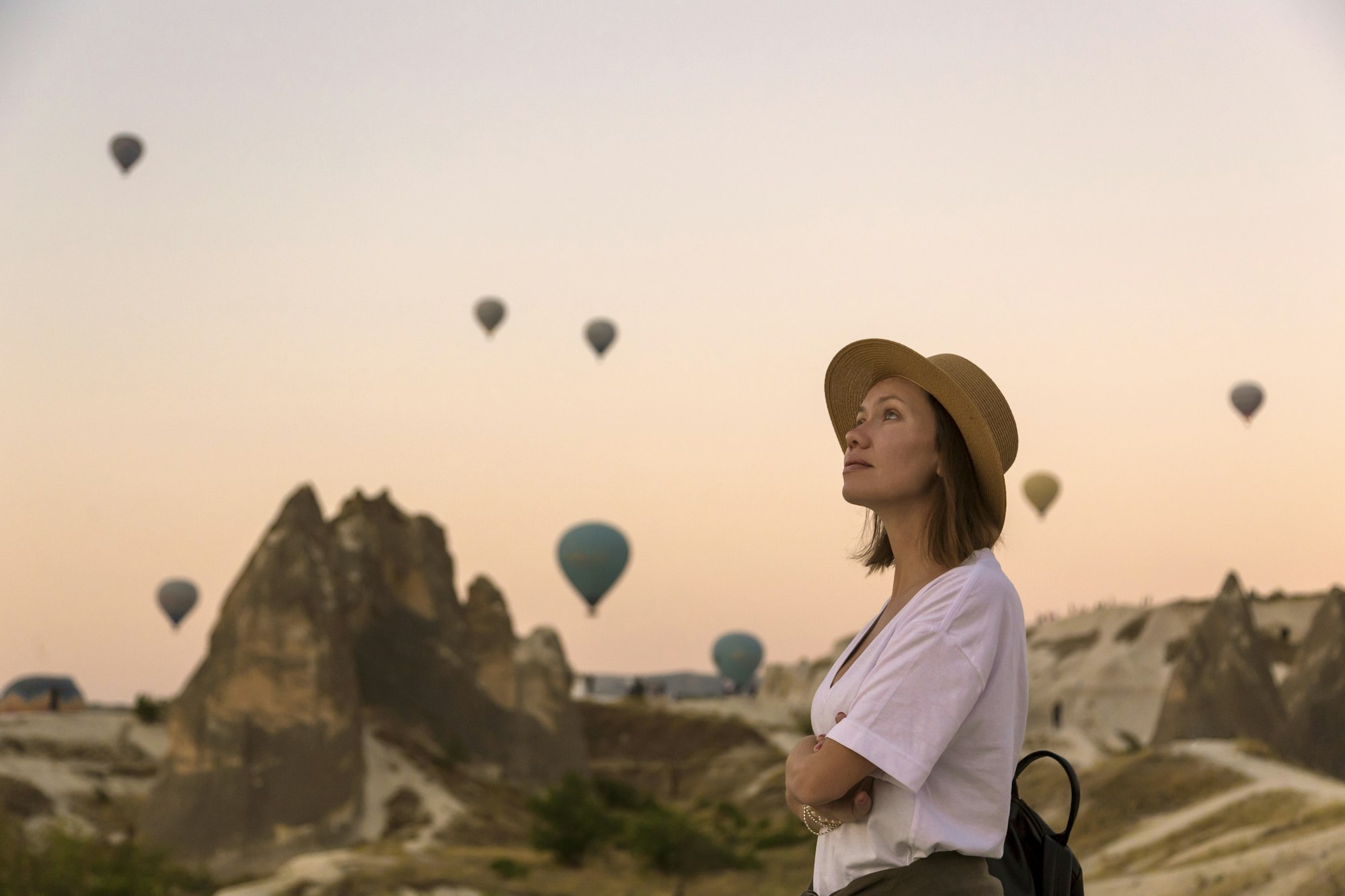 young woman and hot air ballons goreme cappadocia turkey.jpg